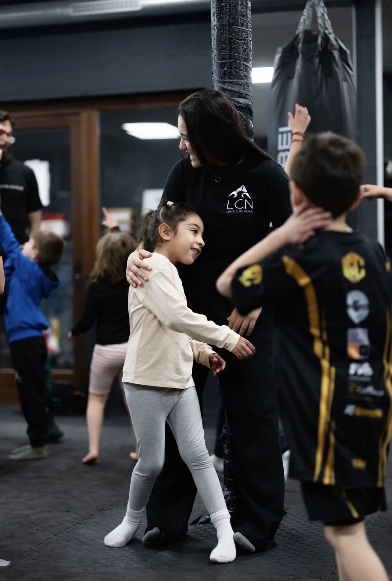 Un coach montre un geste à une enfant pendant un cours jeunes chez CORE